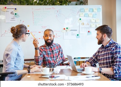 Multiethnic group of young people sitting in conference room and brainstorming on business meeting  Stock Photo