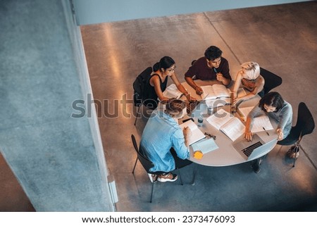 Multiethnic group of young people studying together at a table. Young students in cooperation with their school assignment.