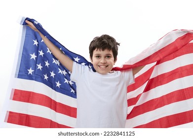 Multiethnic happy patriotic preteen child boy, smart teenager, smiling a cheerful toothy smile, looking at camera, carrying American flag. Citizenships. Immigration concept. 4th July. Independence Day - Shutterstock ID 2232841125