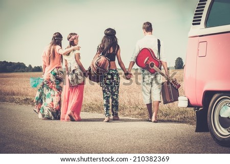Multi-ethnic hippie friends with guitar and luggage 