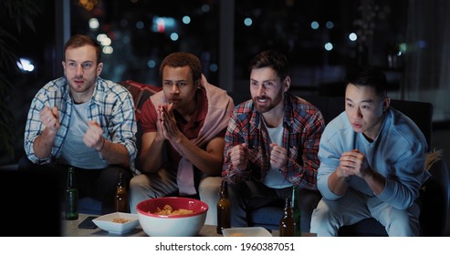 Multi-ethnic Male Team Of Best Friends Partying At Night Watching Favorite Football Soccer Game On Television. Millennial Party. Entertainment Home.. Smartphones.