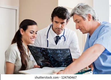 Multiethnic medical professionals reviewing x-ray at hospital reception - Powered by Shutterstock