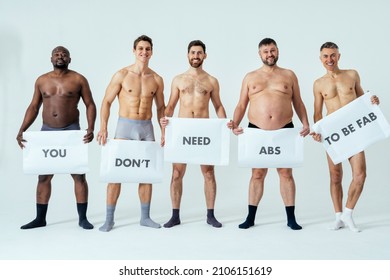 multiethnic men posing for a male edition body positive beauty set showing messages on banners. Shirtless guys with different age, and body wearing boxers underwear - Shutterstock ID 2106151619