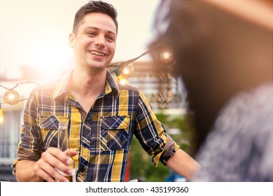 Multi-ethnic Millenial Couple Flirting While Having A Drink On Rooftop Terrasse At Sunset