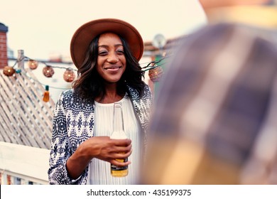 Multi-ethnic Millenial Couple Flirting While Having A Drink On Rooftop Terrasse At Sunset