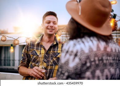 Multi-ethnic Millenial Couple Flirting While Having A Drink On Rooftop Terrasse At Sunset