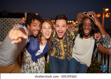 Multi-ethnic Millenial Group Of Friends Taking A Flash Selfie Photo With Mobile Phone On Rooftop Terrasse At Night Time