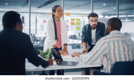 Multi-Ethnic Office Conference Room Businesspeople Meeting at Big Table. Diverse Team of Creative Entrepreneurs Talk, Use Laptop. Specialists work in Digital e-Commerce Startup. - Powered by Shutterstock