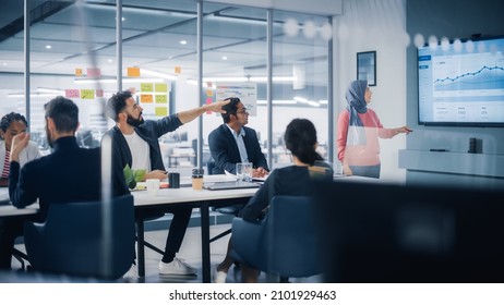 Multi-Ethnic Office Conference Room. Muslim Female CEO Wearing Hijab does Presentation for Group of Managers Talk, Use TV Infographics, Statistics. Businesspeople Brainstorm eCommerce Growth Strategy - Powered by Shutterstock