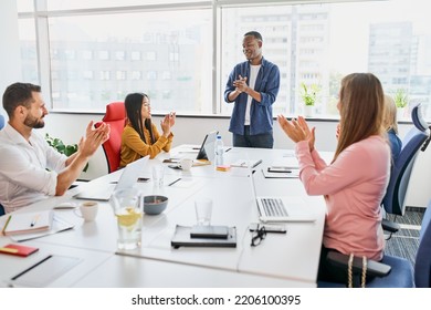 Multi-Ethnic Office Meeting. African American Businessman Doing Presentation For Diverse Business People. Clapping Hands After Successful Speech.