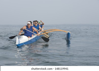 Multiethnic outrigger canoeing team on water