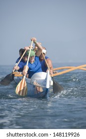 Multiethnic Outrigger Canoeing Team Paddling Canoe In Race