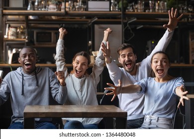 Multi-ethnic people looking at camera sitting at cafe public place screaming shouting feels overjoyed happy by favourite football club team winning get victory, sports betting, lottery winners concept