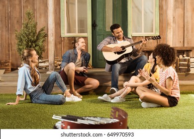 Multiethnic People Spending Time Together, Man Playing Guitar While Other Friends Listening