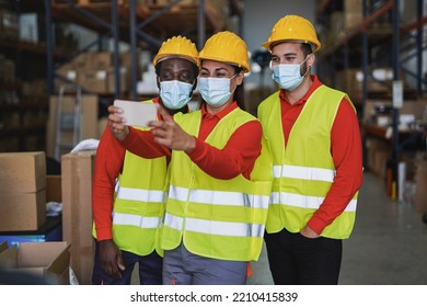 Multiethnic People Working Inside Warehouse While Taking A Selfie Together With Mobile Phone During Coronavirus Outbreak