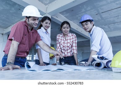 Multiethnic professional construction engineers working with Corporate Colleagues Teamwork and equipment blueprint and Safety glasses at the building site place,focus at hand, Industrial Concept