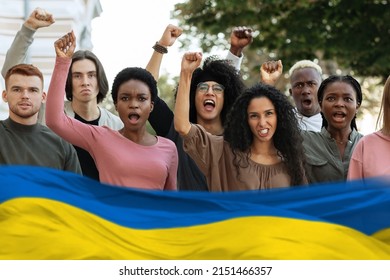 Multiethnic Protestors Striking Against War In Ukraine On The Street, Blue And Yellow Flag. International Group Of Young People Making Riot Next To Government Building, Collage