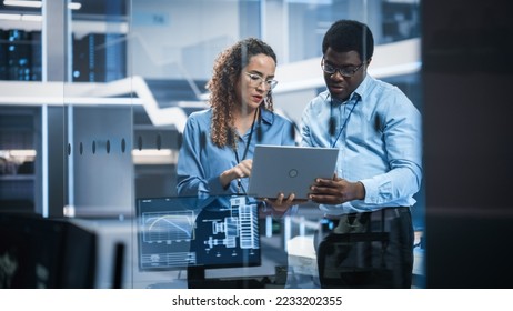 Multiethnic Robotics Engineer Talking to Project Manager, Discussing Robot Dog Concept in High Tech Research and Development Facility. Professional Industrial Scientists Working in the Background. - Shutterstock ID 2233202355