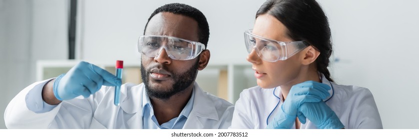 Multiethnic Scientists In Latex Gloves And Goggles Looking At Test Tube In Lab, Banner