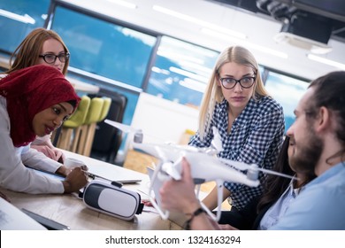 multiethnic startup business team discussing new business plan,working on laptop and tablet computer while learning about drone technology for new business advancement - Shutterstock ID 1324163294
