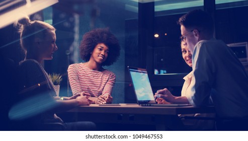 Multiethnic startup business team on meeting in modern night office interior brainstorming, working on laptop - Shutterstock ID 1049467553