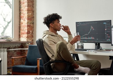 Multiethnic stock trader with glass of water taking capsule of dietary supplements for best mental work. African american trader with glass of water drinks pill while working at home modern office.