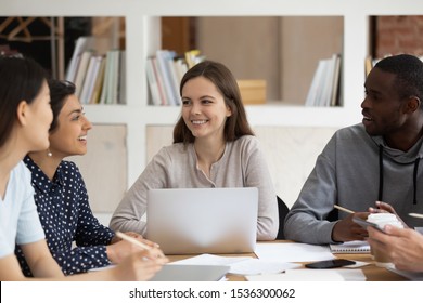 Multi-ethnic students sitting at desk study together, african, indian, asian, european girls and guy preparing for test or exams having friendly warm relationships, learning and racial quality concept