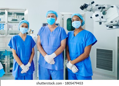 Multi-ethnic Surgical Team In Scrubs, Medical Masks And Disposable Caps