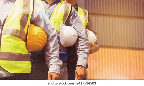 Multiethnic team male Engineer maintenance department site work container service : Group of male workers wearing safety vests and holding helmets outdoor container loading yard meeting teamwork. - Powered by Shutterstock