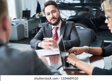 Multi-ethnic Team Of Managers In Formalwear Gathered Together At Car Showroom And Brainstorming On Sales Growth Together