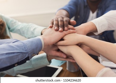 Multiethnic team put hands together, connection, teambuilding and alliance concept. Crop of people in office unite for teamwork and cooperation, copy space