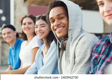 Multiethnic teen company spending time together, sitting outdoor, free space - Shutterstock ID 1403962730