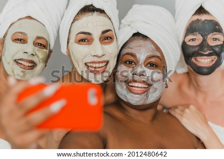 Multiethnic women with face masks taking selfie