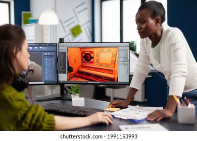 Multiethnic Women Game Designer Looking At Computer With Dual Displays Working Together At Project In Studio Office. Gamer Workers Developing New Online Video Games On Pc With Modern Technology