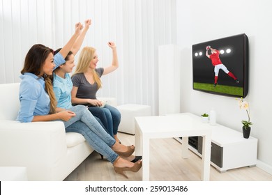 Multiethnic Women Sitting On Couch Cheering Watching Rugby Match