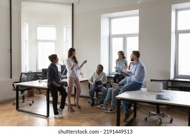 Multiethnic work group talk at meeting, discuss business ideas, sharing creative thoughts. Diverse colleagues office employees speaking negotiating at informal briefing at modern co-working - Shutterstock ID 2191449513