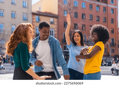 Multiethnic young friends dancing in the city, enjoying party with friends - Powered by Shutterstock