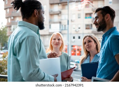 Multiethnic young happy entrepreneurs discussing ideas in a start-up meeting at office terrace - Powered by Shutterstock