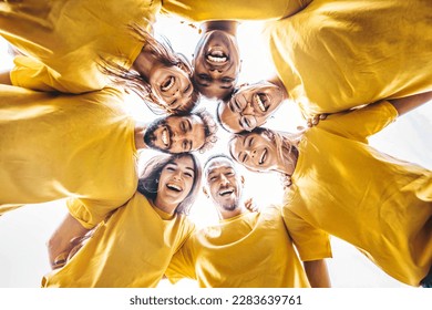 Multiethnic young people hugging outside - Youth community concept with guys and girls supporting each other - Multiracial volunteers standing in circle together 
