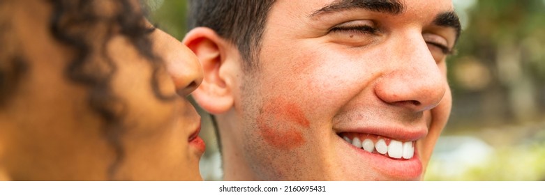 Multiethnic Young People Kiss On Cheek With Lipstick – Portrait Of Two People Kissing On Cheek – Woman Kissing Her Boyfriend -  Happy Loving Woman Kissing Boy Friend On Cheek  