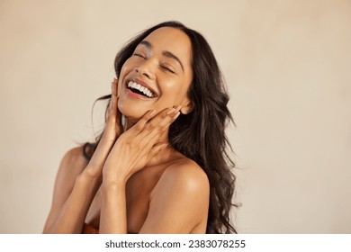 Multiethnic young woman touching her clean and healthy face against background with closed eyes. Latin hispanic woman feeling good. Natural beauty portrait of mexican girl with black long hair.