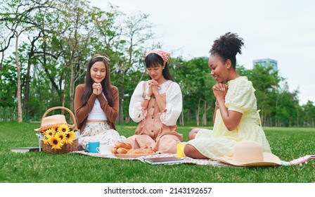 The Multi-ethnic Young Women Are Picnic In The Park. Thanksgiving And Spiritual Prayer For Food.