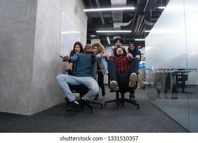 multiethnics startup business team of software developers having fun while racing on office chairs,excited diverse employees laughing enjoying funny activity at work break,  - Shutterstock ID 1331510357