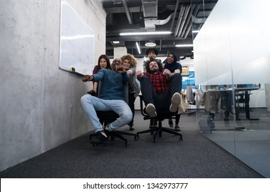 multiethnics startup business team of software developers having fun while racing on office chairs,excited diverse employees laughing enjoying funny activity at work break, - Shutterstock ID 1342973777