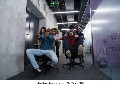 multiethnics startup business team of software developers having fun while racing on office chairs,excited diverse employees laughing enjoying funny activity at work break,  - Shutterstock ID 1342973789