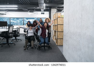 Multiethnics Startup Business Team Of Software Developers Having Fun While Racing On Office Chairs,excited Diverse Employees Laughing Enjoying Funny Activity At Work Break, 