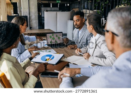 Multifaceted team prepares action plan with timelines and charts