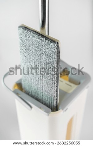 A multifunctional cleaning tool showcases a microfiber pad nestled in a storage container, highlighting its practicality for effective home cleaning tasks.