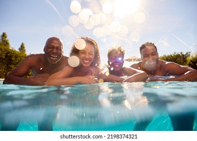 Multi-Generation Family With Adult Offspring On Summer Holiday On Inflatable In Swimming Pool - Powered by Shutterstock