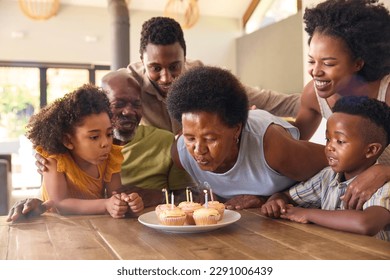 Multi-Generation Family Celebrate Grandmother's Birthday With Cake And Candles Around Table At Home - Powered by Shutterstock